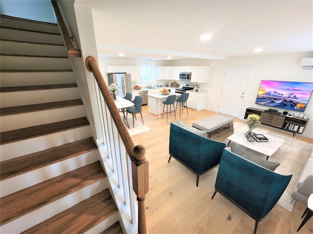 living area with stairs, light wood-style floors, and recessed lighting