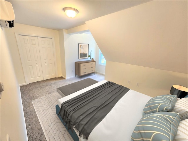 carpeted bedroom with a closet, baseboards, and a wall unit AC
