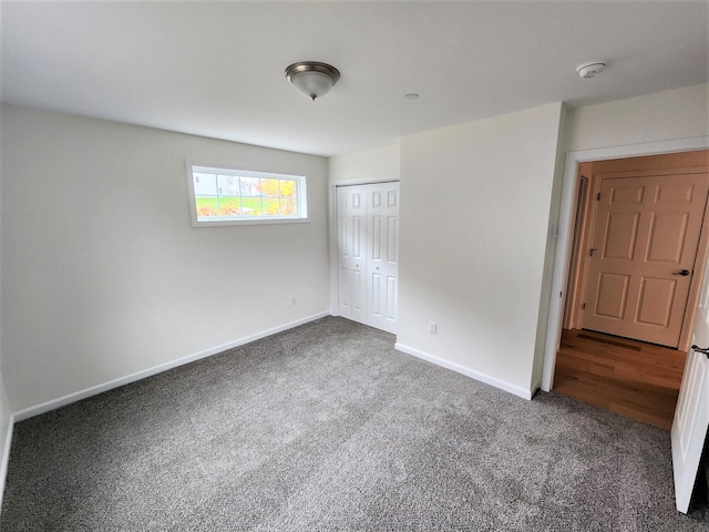 unfurnished bedroom featuring baseboards, a closet, and carpet floors