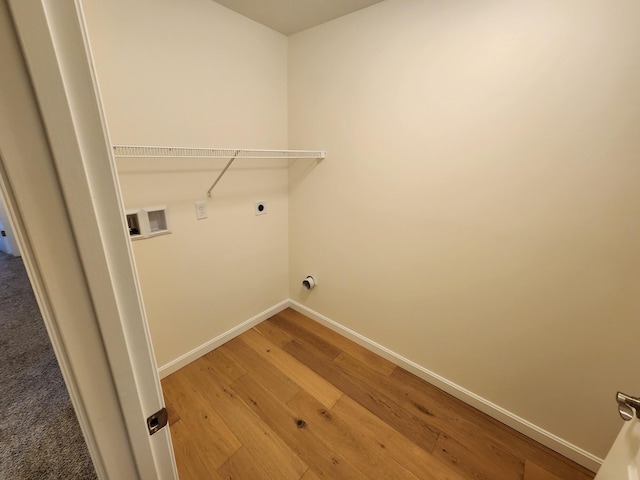 laundry area featuring laundry area, hookup for an electric dryer, washer hookup, baseboards, and light wood-style floors