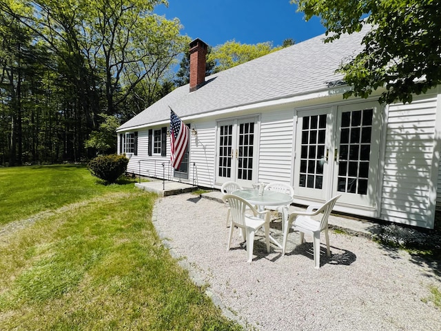 329 Salt Pond Rd, Blue Hill, ME 04614 - rear view of house featuring french doors, a patio area, a chimney, a lawn, and roof with shingles
