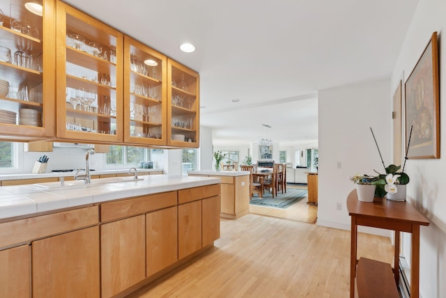388 High Head Rd, Harpswell, ME 04079 - kitchen with light wood-style flooring, a sink, glass insert cabinets, recessed lighting, and tile countertops