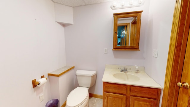 half bath with toilet, tile patterned flooring, and vanity