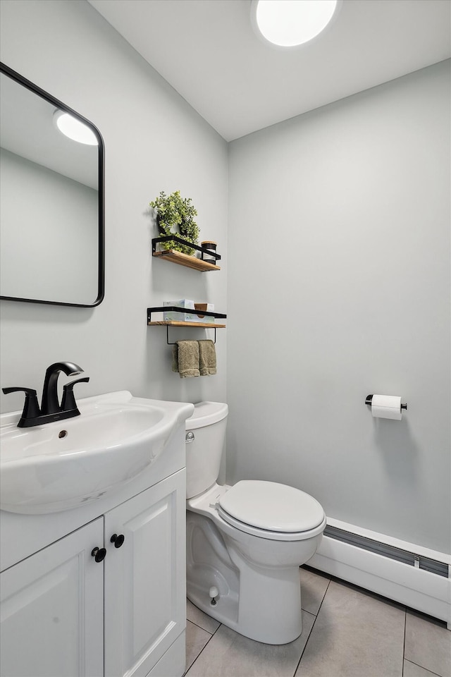 half bath featuring a baseboard radiator, toilet, tile patterned flooring, and vanity