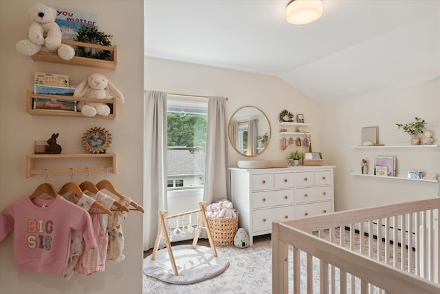 bedroom with a crib and lofted ceiling