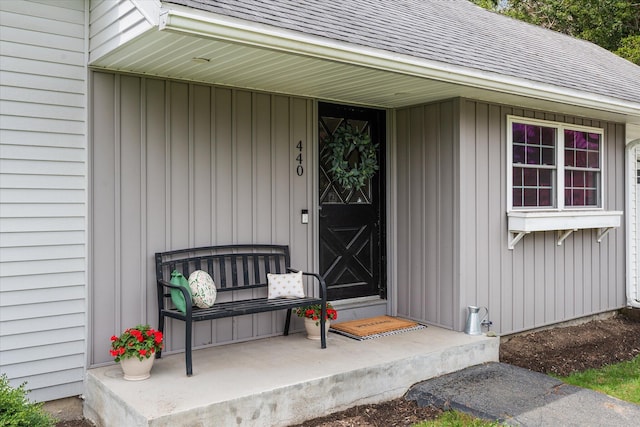 entrance to property featuring roof with shingles