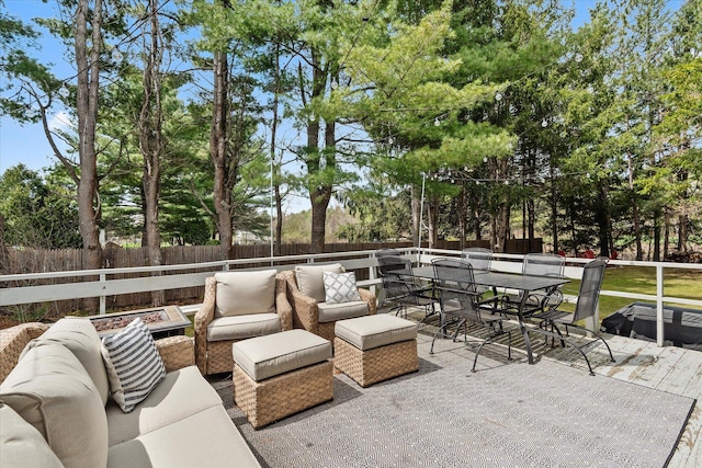 view of patio featuring outdoor lounge area, a fenced backyard, outdoor dining area, and view of wooded area
