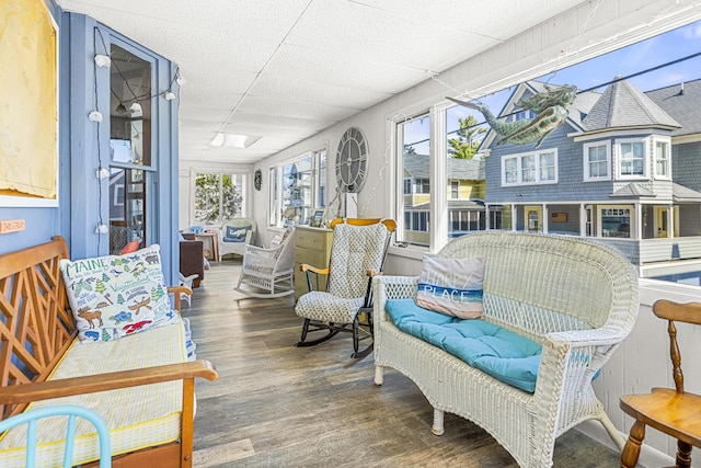 sunroom with wood finished floors and a drop ceiling