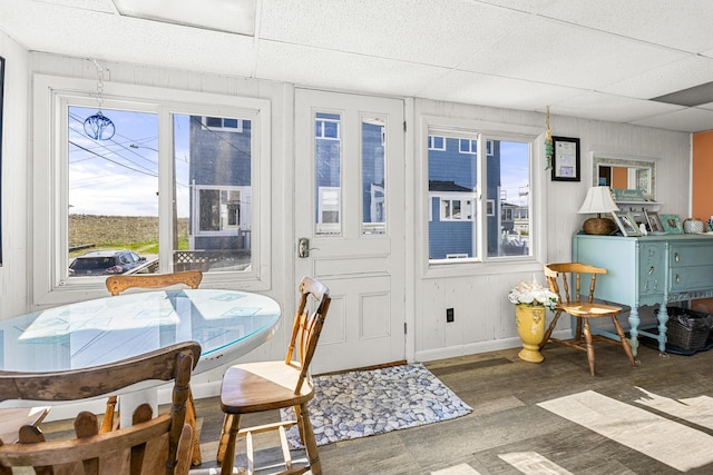 dining room featuring a paneled ceiling, wood finished floors, baseboards, and plenty of natural light
