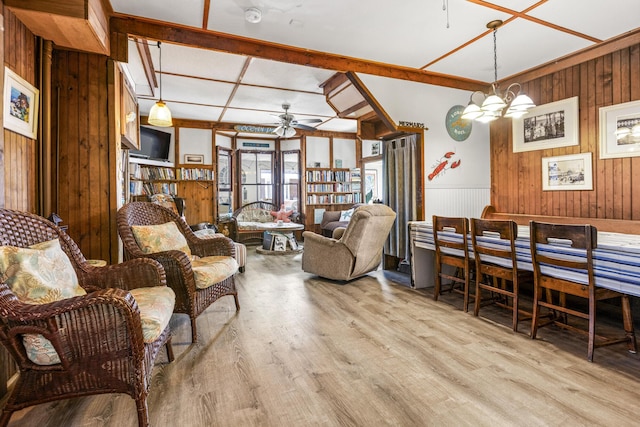 living room with wood walls, ceiling fan, light wood-style flooring, and wainscoting