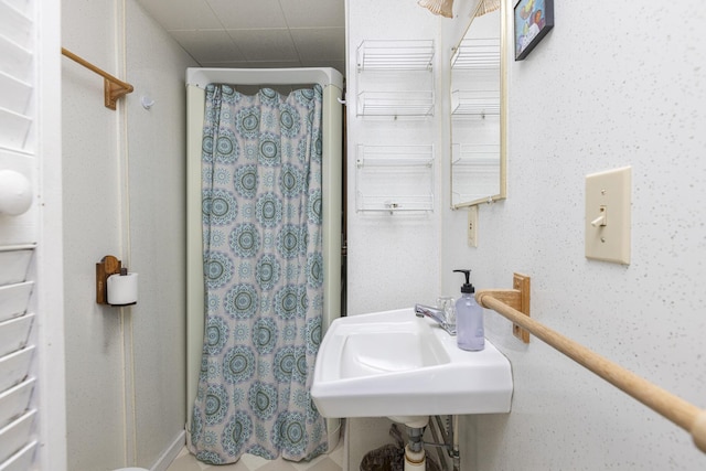 bathroom featuring curtained shower and a sink