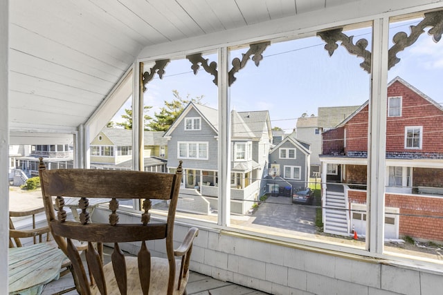 sunroom / solarium featuring a residential view and lofted ceiling