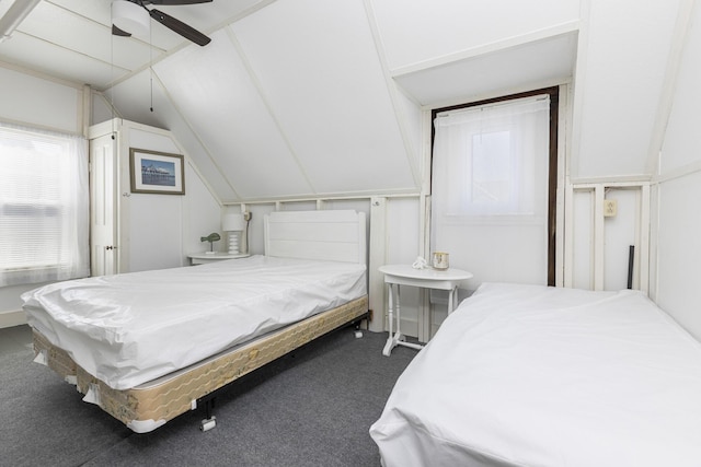 carpeted bedroom with multiple windows, vaulted ceiling, and a ceiling fan