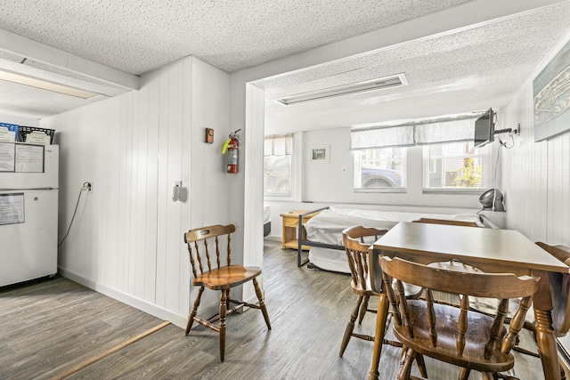 dining room featuring wood finished floors and a textured ceiling