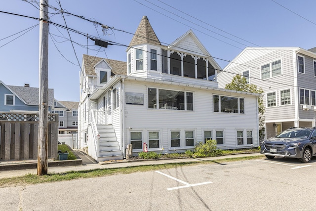 view of front of house featuring uncovered parking and fence