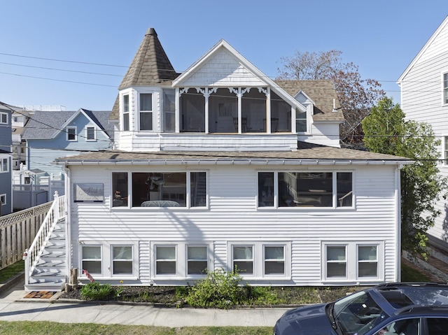 view of front of home with a shingled roof and fence