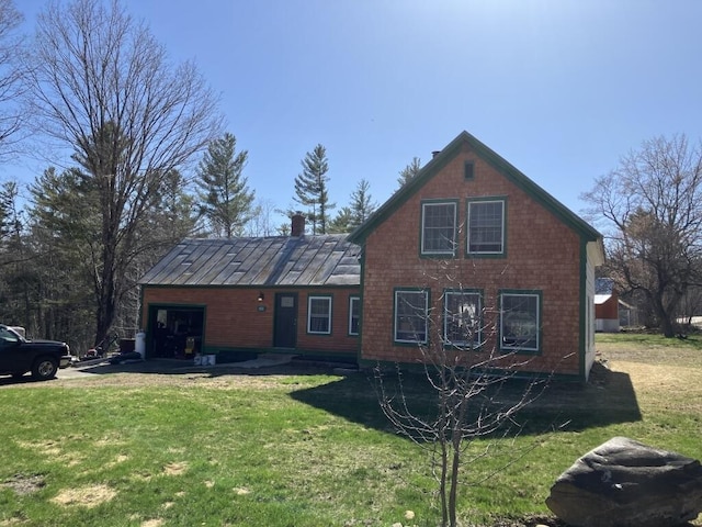 view of front facade featuring a garage, a front lawn, and a chimney