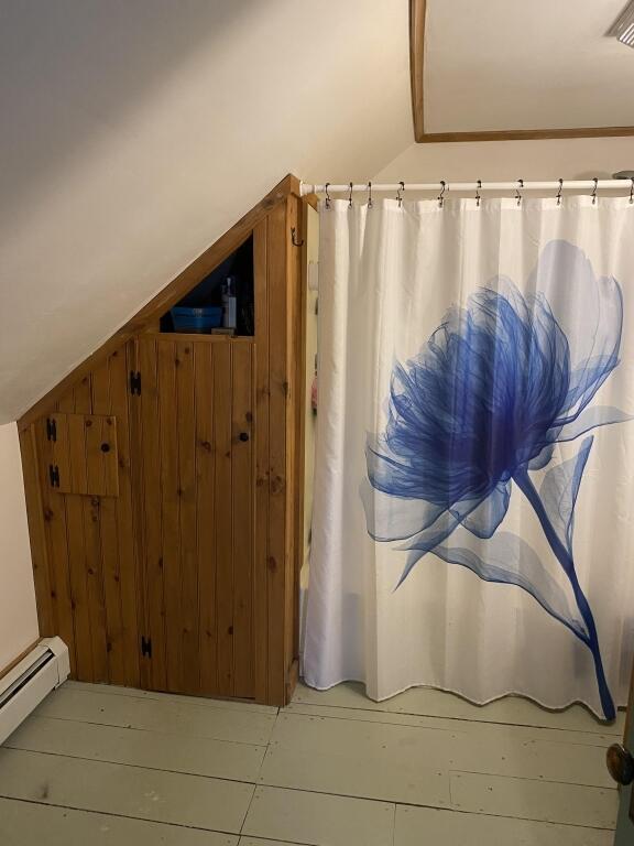 bathroom with baseboard heating and a shower with curtain