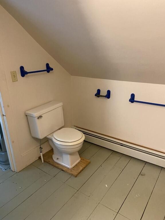 bathroom featuring toilet, lofted ceiling, and baseboard heating
