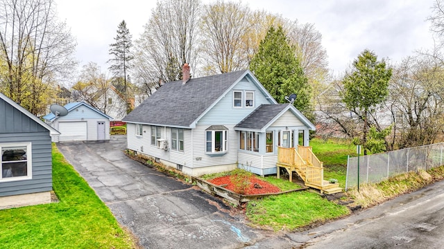 bungalow with a garage, an outdoor structure, roof with shingles, fence, and a chimney
