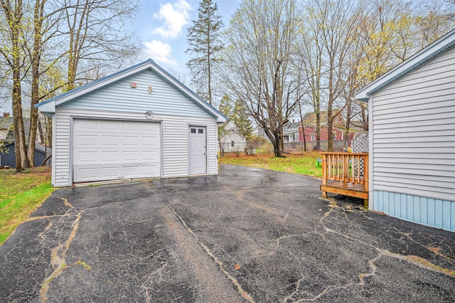 detached garage featuring fence and driveway