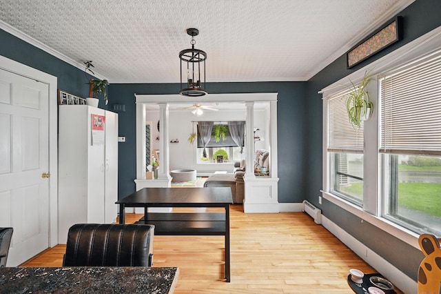 home office featuring ceiling fan, healthy amount of natural light, a baseboard radiator, light wood-style flooring, and crown molding