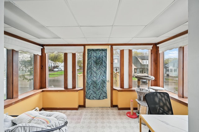 sunroom featuring plenty of natural light, tile patterned floors, baseboards, and a drop ceiling