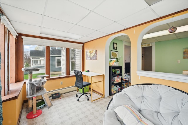 bedroom with a drop ceiling, a desk, baseboard heating, arched walkways, and baseboards