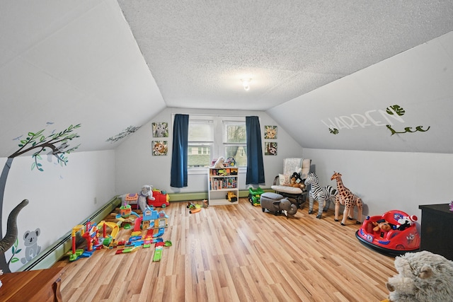 rec room featuring wood finished floors, a baseboard radiator, and vaulted ceiling