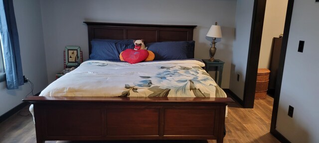 bedroom with wood finished floors and baseboards