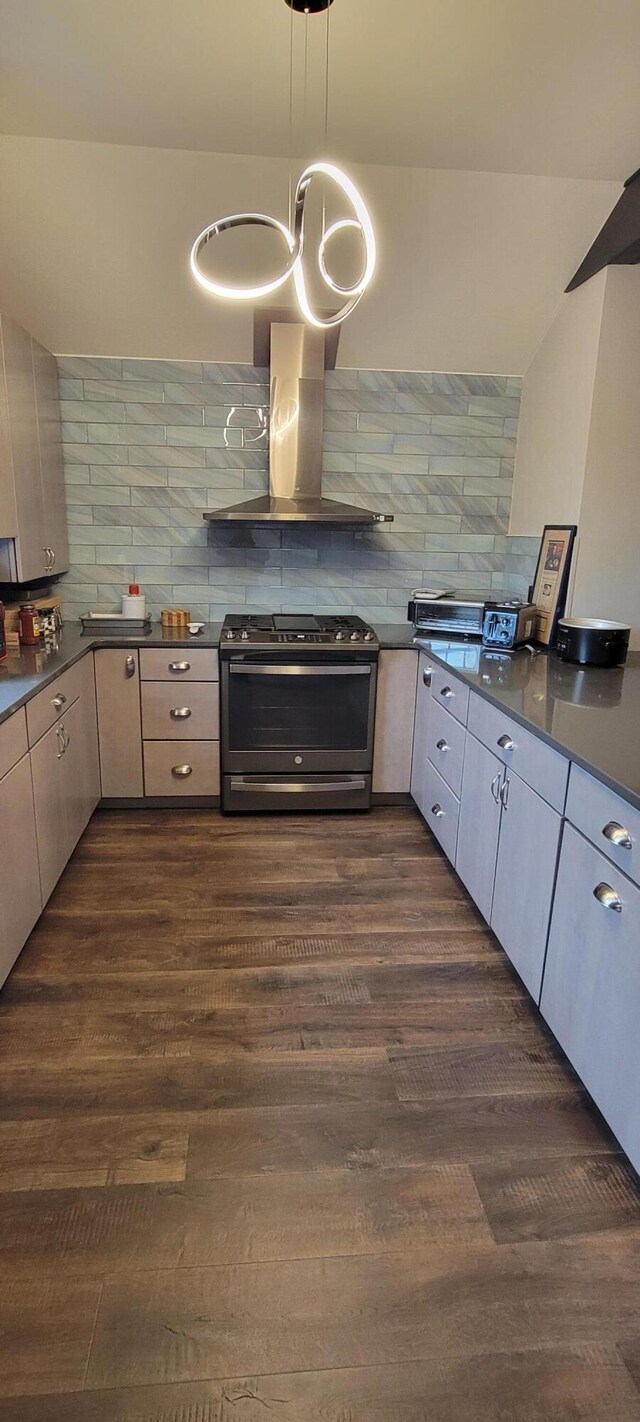 kitchen featuring gas stove, wall chimney range hood, dark countertops, dark wood-style flooring, and decorative backsplash