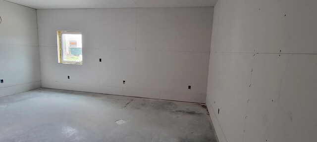 spare room featuring unfinished concrete flooring