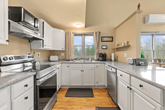 150 Holmes Rd, Scarborough, ME 04074 - kitchen with appliances with stainless steel finishes, a wall unit AC, a sink, white cabinets, and plenty of natural light