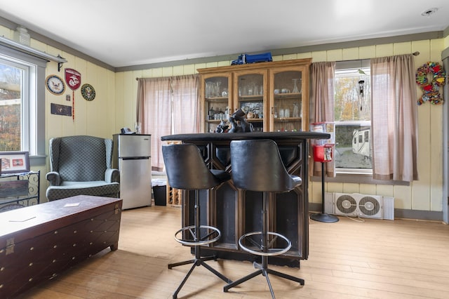 bar featuring freestanding refrigerator and hardwood / wood-style floors