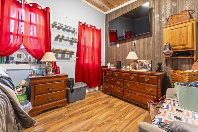 bedroom featuring wood walls, wood finished floors, and ornamental molding