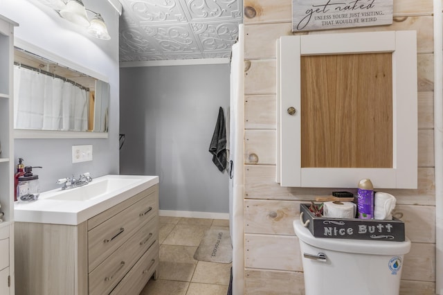 full bathroom with vanity, baseboards, an ornate ceiling, and tile patterned floors