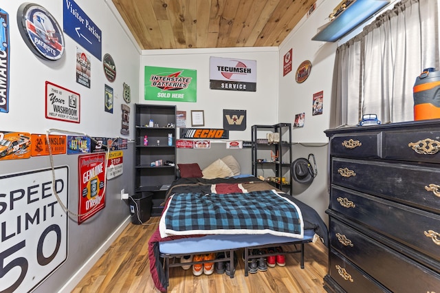 bedroom featuring wooden ceiling, wood finished floors, and baseboards