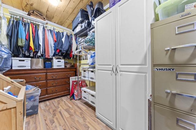 walk in closet with light wood finished floors