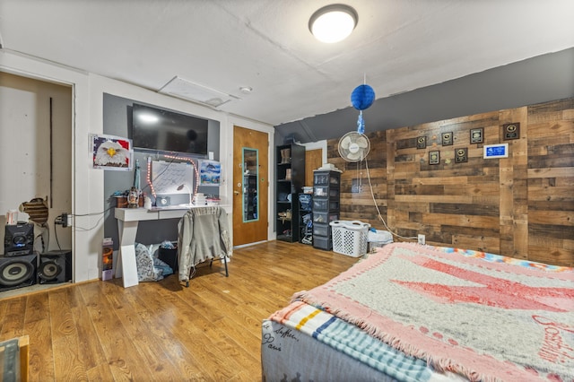 bedroom featuring wood finished floors and wood walls