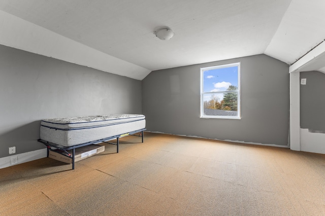 additional living space with vaulted ceiling and carpet flooring
