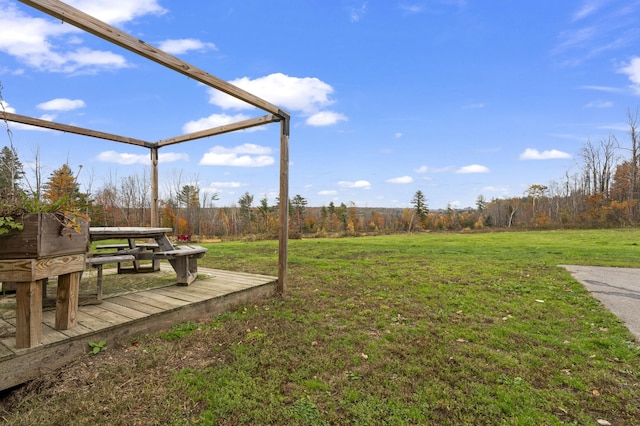 view of grassy yard with a wooden deck