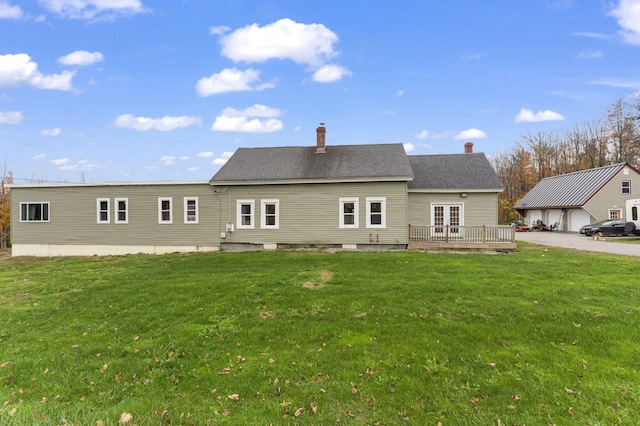 rear view of house featuring a yard, french doors, a wooden deck, and a chimney