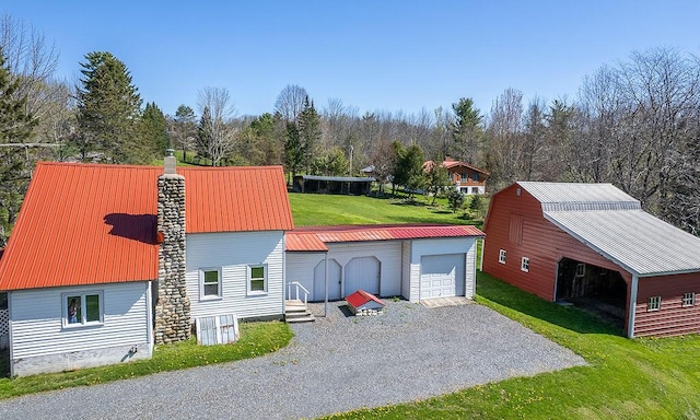 225 Todds Corner Rd, Saint Albans, ME 04971 - view of side of home featuring an outdoor structure, a lawn, gravel driveway, metal roof, and a chimney