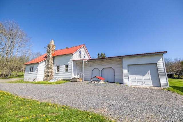 225 Todds Corner Rd, Saint Albans, ME 04971 - view of front of property featuring metal roof, a garage, gravel driveway, and a chimney