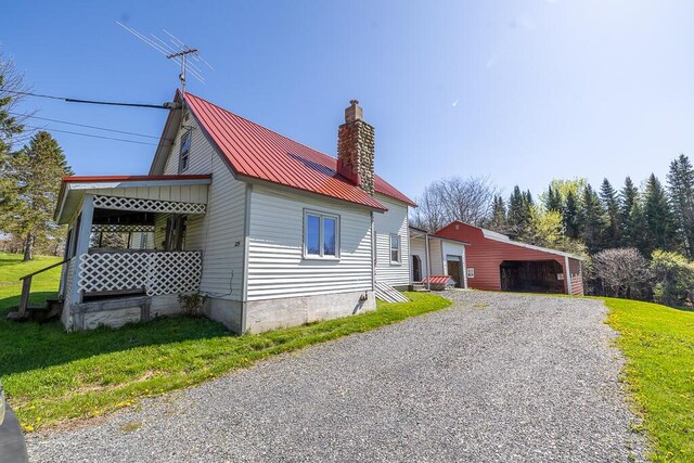 225 Todds Corner Rd, Saint Albans, ME 04971 - view of home's exterior with a chimney, a yard, metal roof, an outdoor structure, and a garage