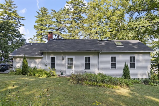 back of house featuring a yard and a chimney