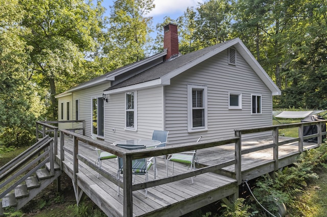 rear view of property with a chimney and a deck