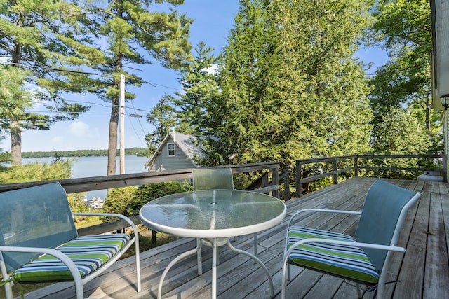 wooden deck with outdoor dining area and a water view