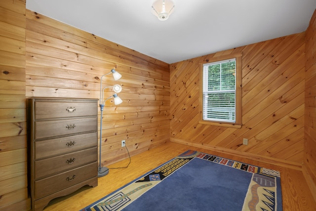 bedroom with wooden walls and wood finished floors