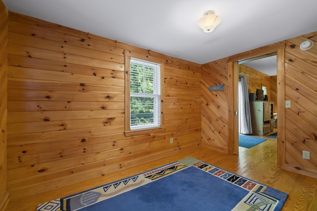 spare room featuring wood finished floors and wood walls